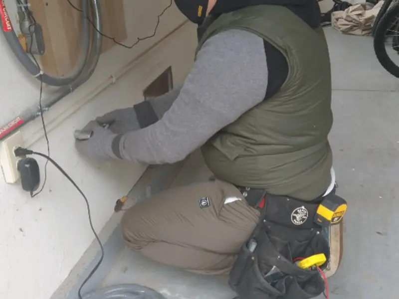 Electrician performing outlet wiring in a Killingworth garage